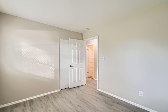 unfurnished bedroom featuring wood finished floors and baseboards