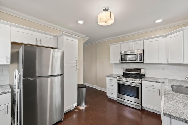 kitchen featuring stainless steel appliances, crown molding, backsplash, white cabinetry, and recessed lighting