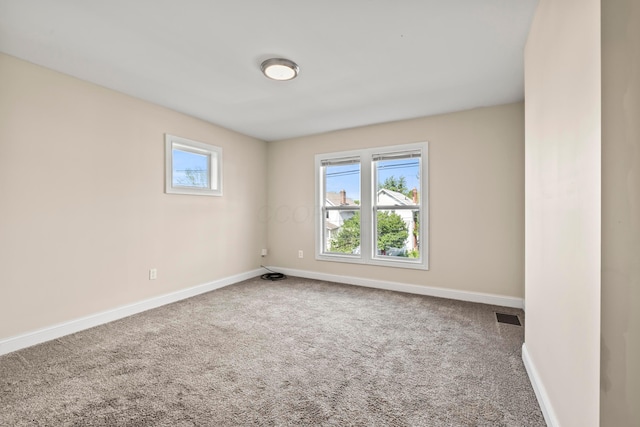 carpeted empty room featuring baseboards