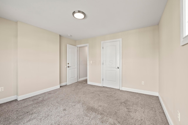 empty room featuring carpet flooring and baseboards
