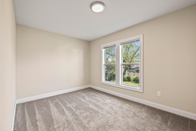 spare room with baseboards and carpet