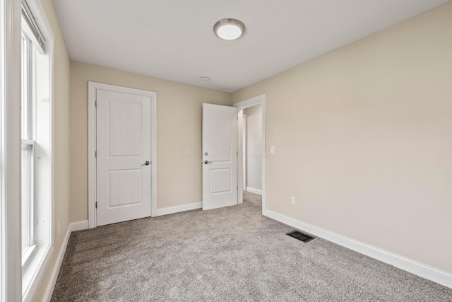 unfurnished bedroom with carpet floors and baseboards