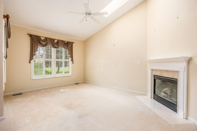 unfurnished living room with light carpet, a fireplace, a ceiling fan, baseboards, and high vaulted ceiling