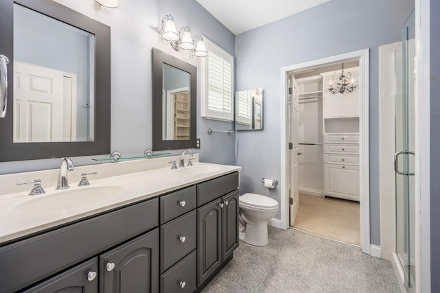 bathroom with a shower stall, double vanity, toilet, a spacious closet, and baseboards