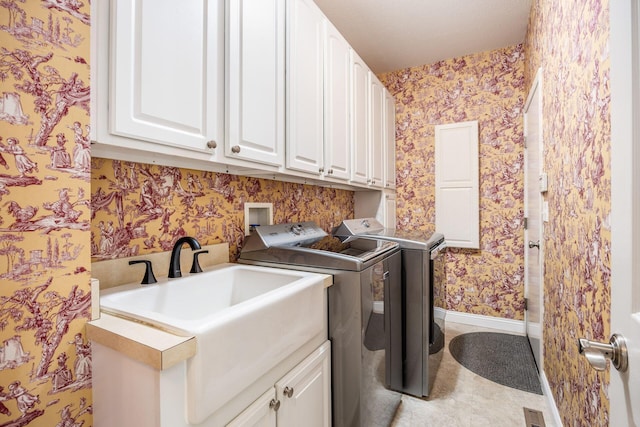 laundry room featuring wallpapered walls, cabinet space, washer and clothes dryer, and baseboards