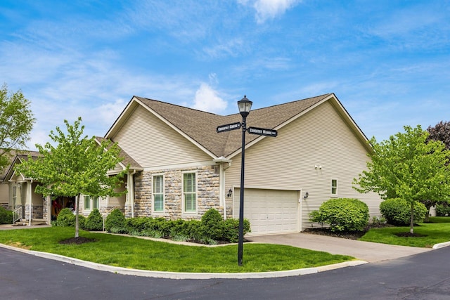 view of front of property featuring a front lawn, driveway, stone siding, and roof with shingles