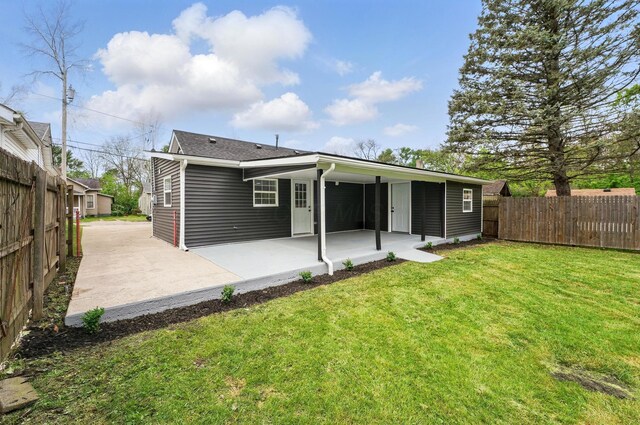 rear view of house with a lawn, a patio area, and fence