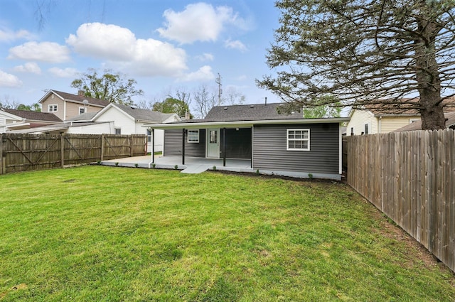 back of house with a fenced backyard, a patio area, and a yard