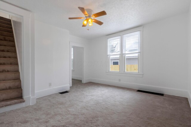 233-235 N 13th St, Newark, OH 43055 - unfurnished living room featuring stairs, carpet flooring, a ceiling fan, and baseboards