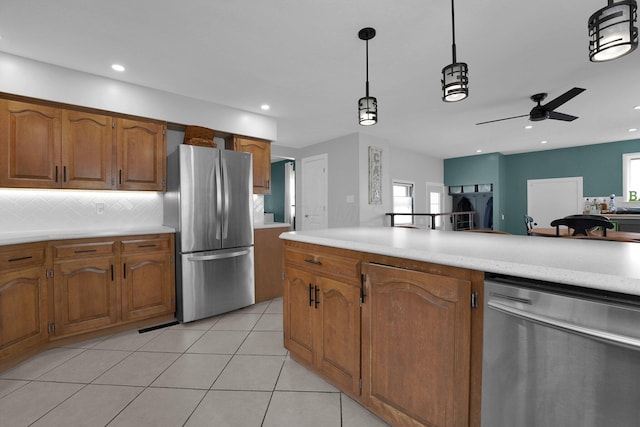 591 French Dr, Columbus, OH 43228 - kitchen featuring appliances with stainless steel finishes, brown cabinetry, light countertops, tasteful backsplash, and a ceiling fan