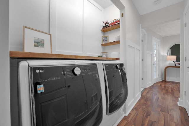 591 French Dr, Columbus, OH 43228 - clothes washing area featuring washer and dryer, wood finished floors, and cabinet space