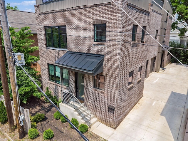 460 S Lane Unit 460, Columbus, OH 43206 - view of front of house featuring brick siding, concrete driveway, and a standing seam roof