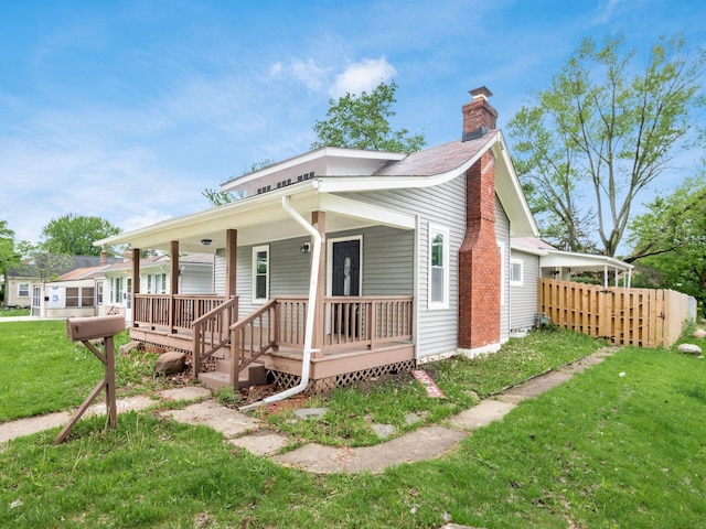 3147 Grasmere Ave, Columbus, OH 43224 - bungalow-style house featuring covered porch, fence, a front lawn, and a chimney