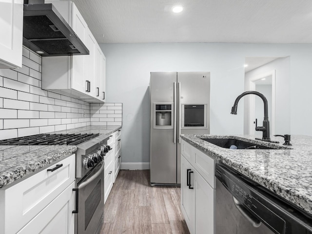 3147 Grasmere Ave, Columbus, OH 43224 - kitchen featuring light stone countertops, a sink, wall chimney exhaust hood, light wood-style floors, and appliances with stainless steel finishes