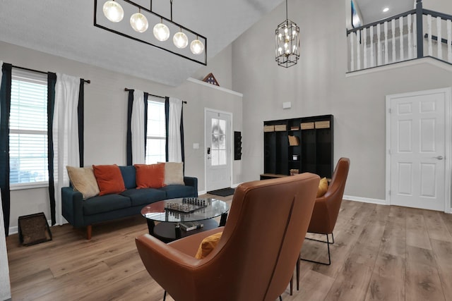 4215 Mack Ct, Powell, OH 43065 - living area featuring high vaulted ceiling, a chandelier, plenty of natural light, wood finished floors, and baseboards