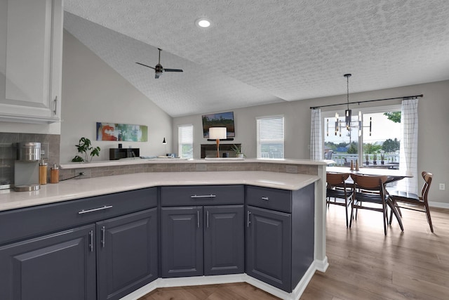 4215 Mack Ct, Powell, OH 43065 - kitchen with a peninsula, light countertops, open floor plan, a textured ceiling, and plenty of natural light