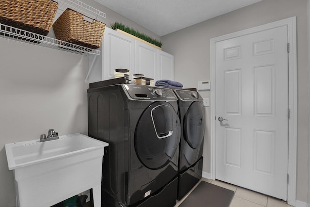 4215 Mack Ct, Powell, OH 43065 - laundry area featuring washing machine and clothes dryer, cabinet space, and light tile patterned flooring