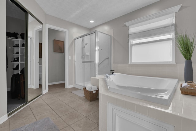 4215 Mack Ct, Powell, OH 43065 - full bath featuring a shower stall, a bath, a walk in closet, tile patterned flooring, and a textured ceiling