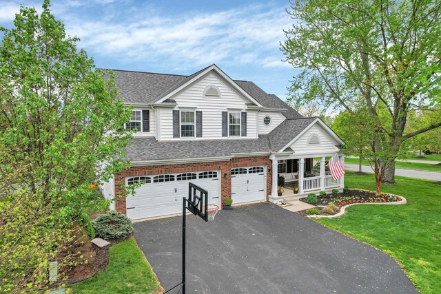 4215 Mack Ct, Powell, OH 43065 - traditional-style home with asphalt driveway, an attached garage, a shingled roof, a porch, and a front lawn