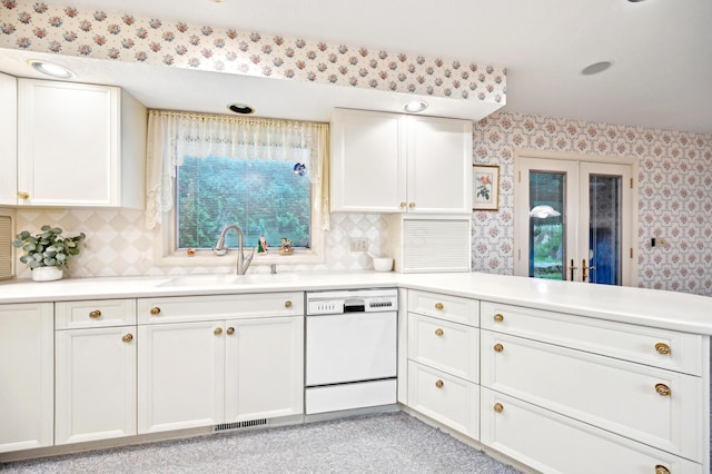 685 Dogwood Ln, Newark, OH 43055 - kitchen featuring dishwasher, wallpapered walls, a sink, white cabinets, and light countertops