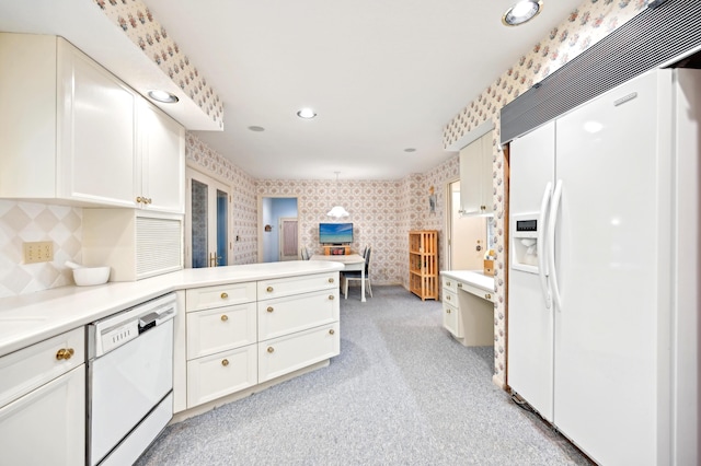 685 Dogwood Ln, Newark, OH 43055 - kitchen with white appliances, a peninsula, wallpapered walls, white cabinets, and light colored carpet