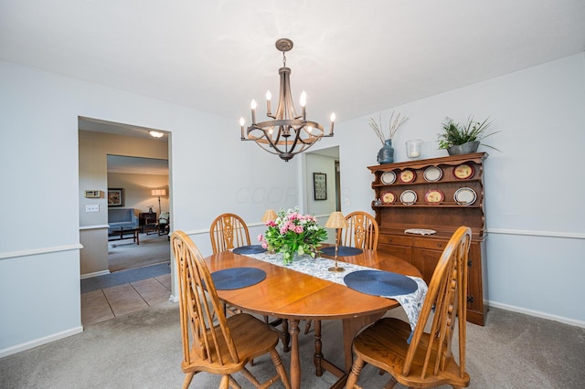 1211 Darcann Dr, Columbus, OH 43220 - tiled dining area with carpet flooring, a chandelier, and baseboards