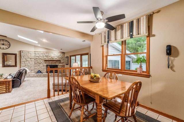 2040 Riggs Rd, Newark, OH 43055 - dining space with lofted ceiling, light tile patterned flooring, a fireplace, a ceiling fan, and light carpet