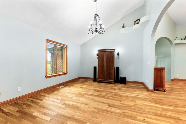 3100 Kropp Rd, Grove City, OH 43123 - unfurnished dining area with light wood-type flooring, arched walkways, high vaulted ceiling, baseboards, and a chandelier