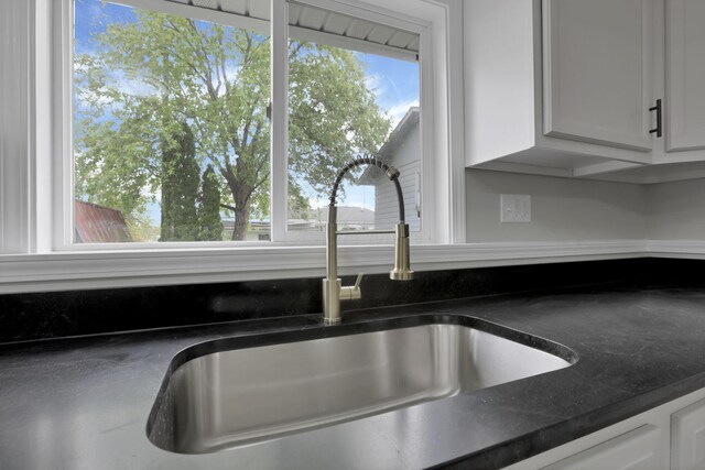 193 Seymour Ave, Buckeye Lake, OH 43008 - kitchen view of a sink, white cabinetry, and dark countertops