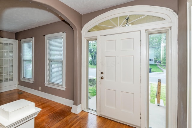 foyer entrance with wood finished floors and baseboards