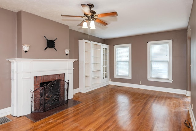 unfurnished living room with baseboards, wood finished floors, and ceiling fan