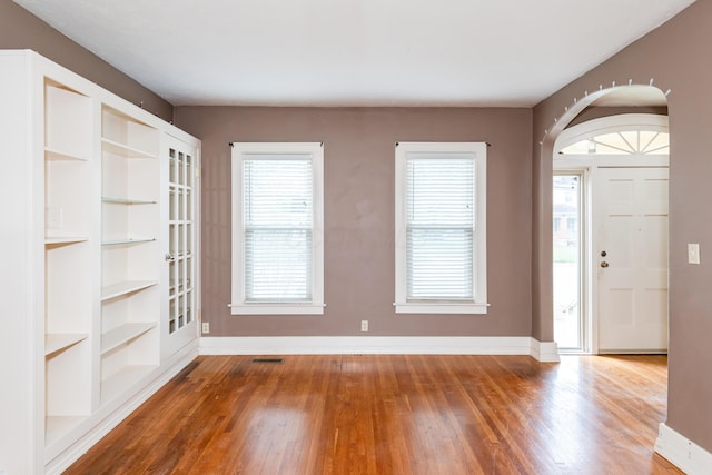 foyer entrance with wood finished floors and baseboards