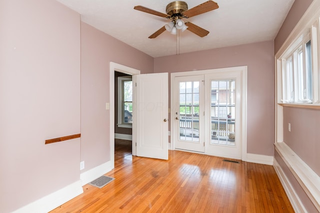 doorway to outside with light wood finished floors, baseboards, and ceiling fan