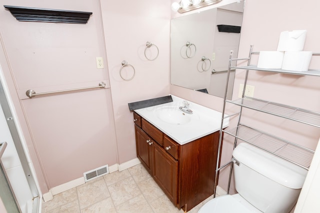 bathroom featuring baseboards, toilet, and vanity