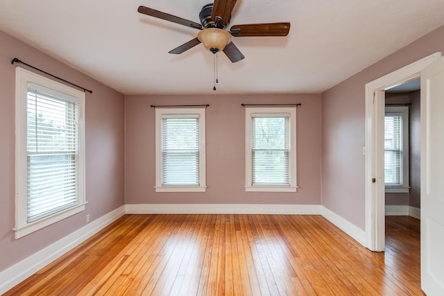 empty room featuring light wood-style flooring, baseboards, and ceiling fan