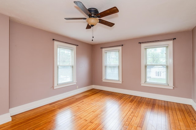 empty room featuring baseboards, light wood-style flooring, and ceiling fan
