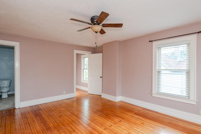 unfurnished room with baseboards, light wood-type flooring, ceiling fan, and plenty of natural light