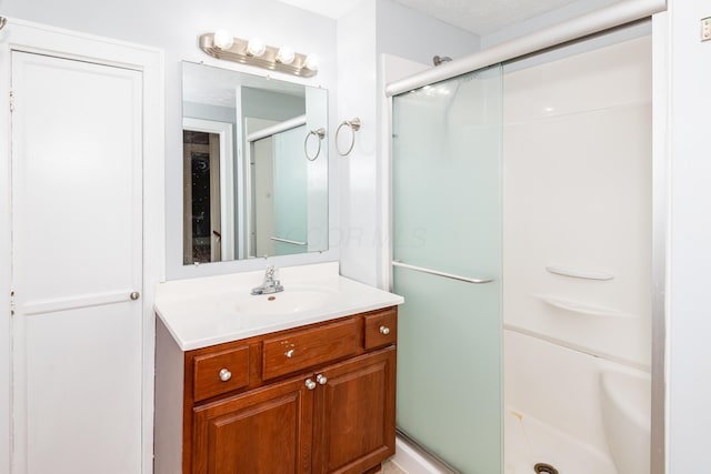 bathroom with a shower stall and vanity