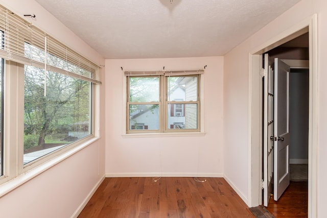 unfurnished room with wood finished floors and baseboards