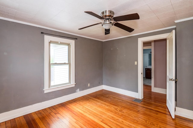 unfurnished room with baseboards, light wood-type flooring, crown molding, and a ceiling fan