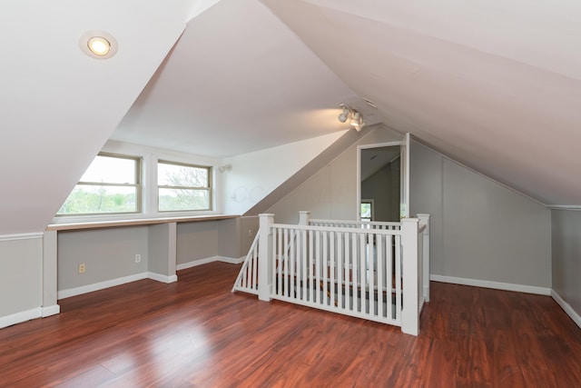 bonus room with vaulted ceiling, wood finished floors, and baseboards