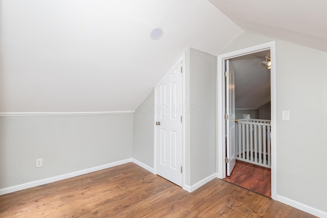 bonus room featuring vaulted ceiling, wood finished floors, and baseboards