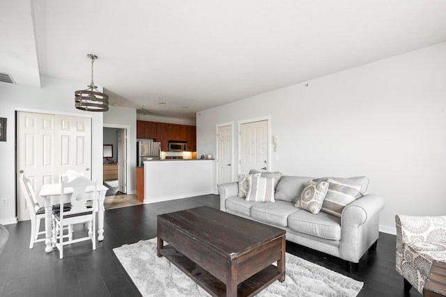 living room with dark wood-type flooring and baseboards
