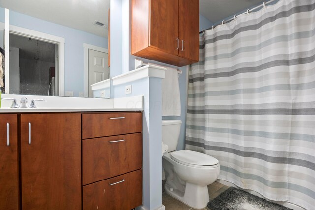 full bathroom with toilet, vanity, and curtained shower