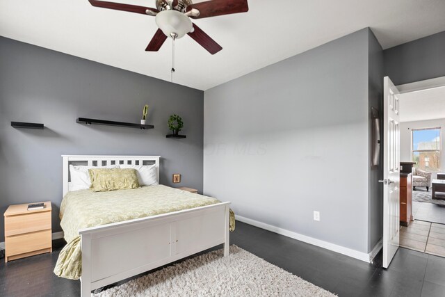 bedroom with baseboards, ceiling fan, and wood finished floors