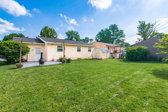1825 Ormond Ave, Columbus, OH 43224 - back of property with a patio area, a storage shed, stucco siding, and an outbuilding