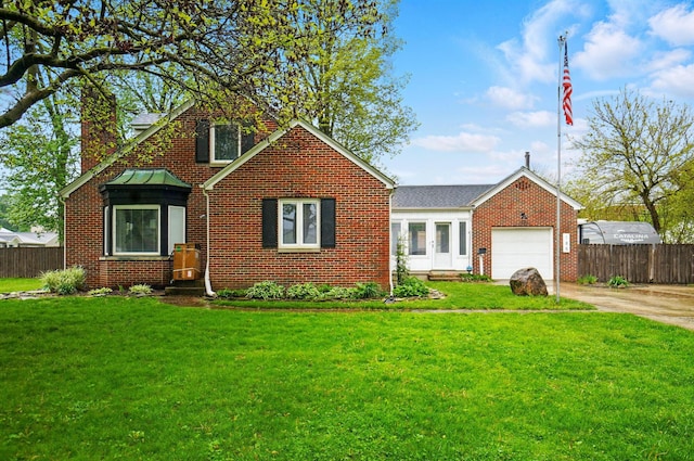 view of front facade with a chimney, an attached garage, driveway, and brick siding
