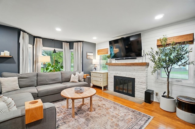 living room featuring a fireplace, wood finished floors, and recessed lighting