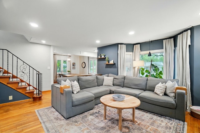 living area with light wood finished floors, stairs, and recessed lighting
