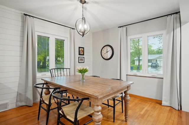 dining room with light wood-type flooring and a chandelier